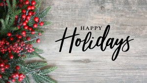 Happy Holidays Script Text with Holiday Evergreen Branches and Red Berries on Side Over Rustic Wood Background